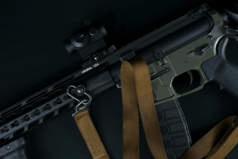 an automatic rifle and a sling are next to each other