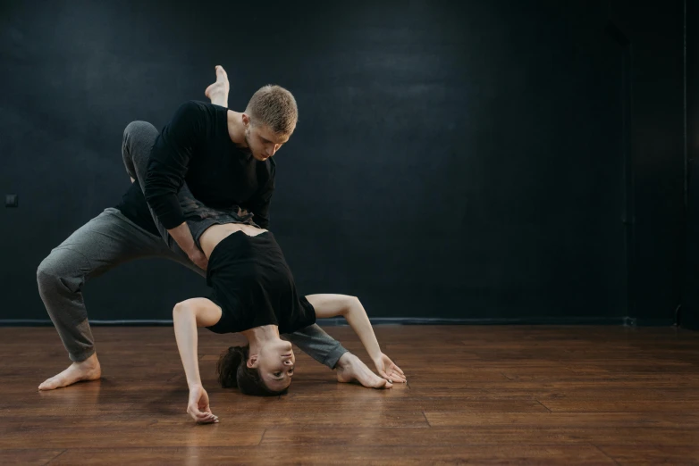 two people are on the ground while they practice dancing