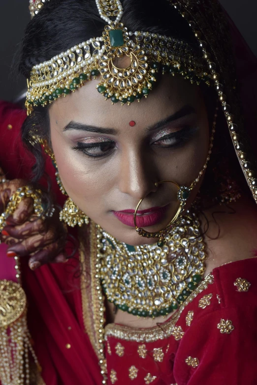 an indian bride dressed in red posing with her hands on her hip