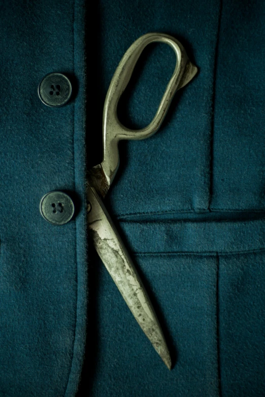 a green jacket with a pair of scissors sticking out of it