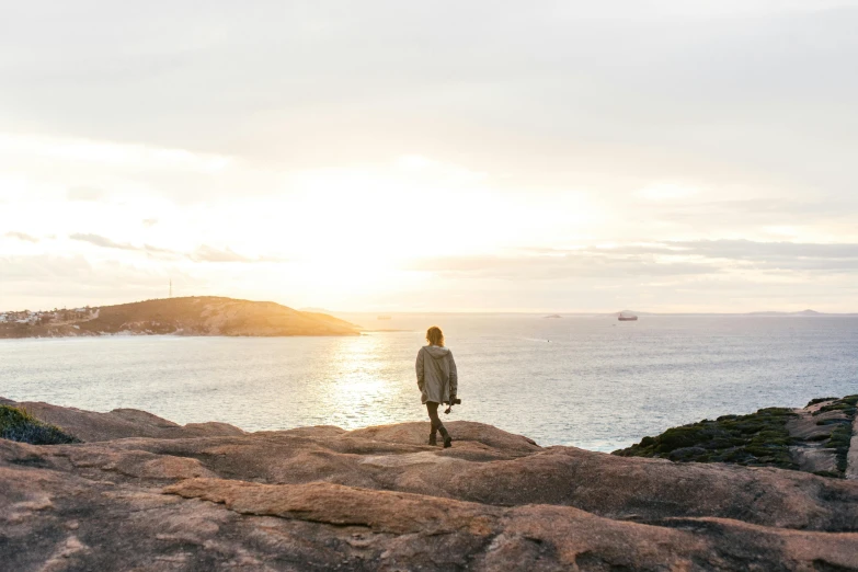 a man is standing on top of a large rock