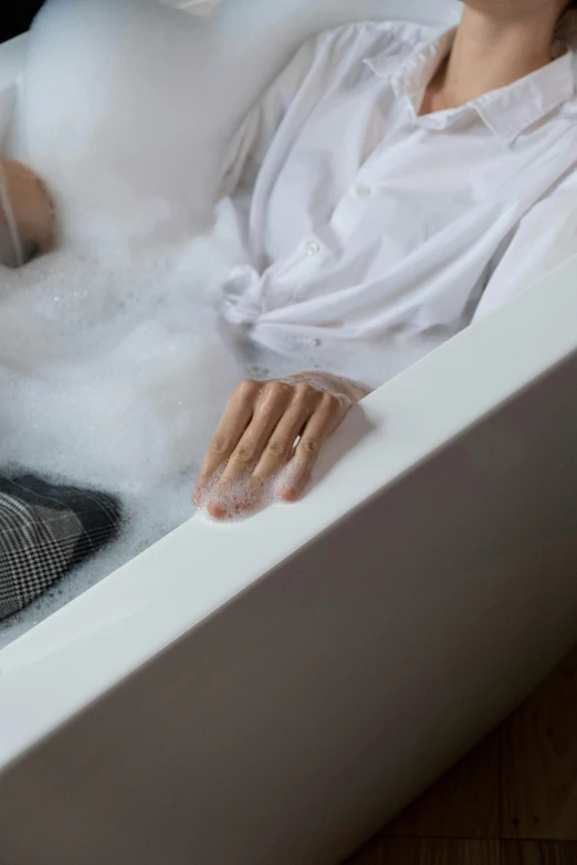 a woman sitting in a bathtub in a bathroom