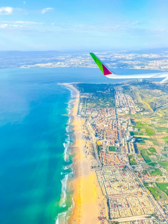 an aerial view of a beach, ocean, and town