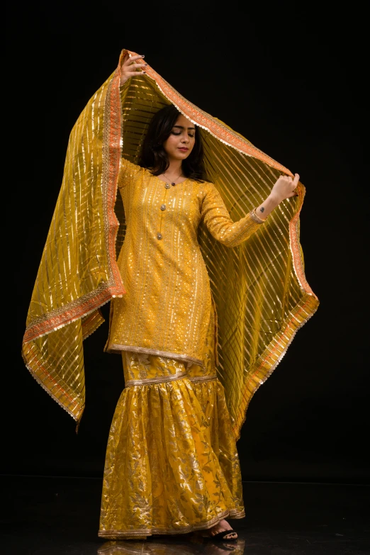 a woman in yellow dress and a sheer sheer cover over her head