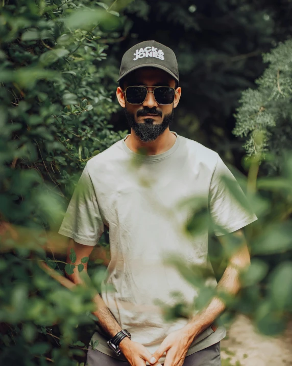 a bearded man in a white shirt and a black hat