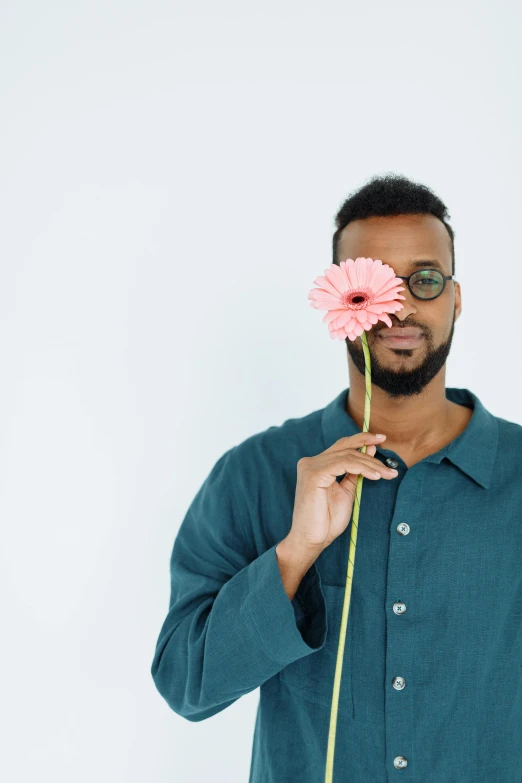 a black man with glasses and a flower