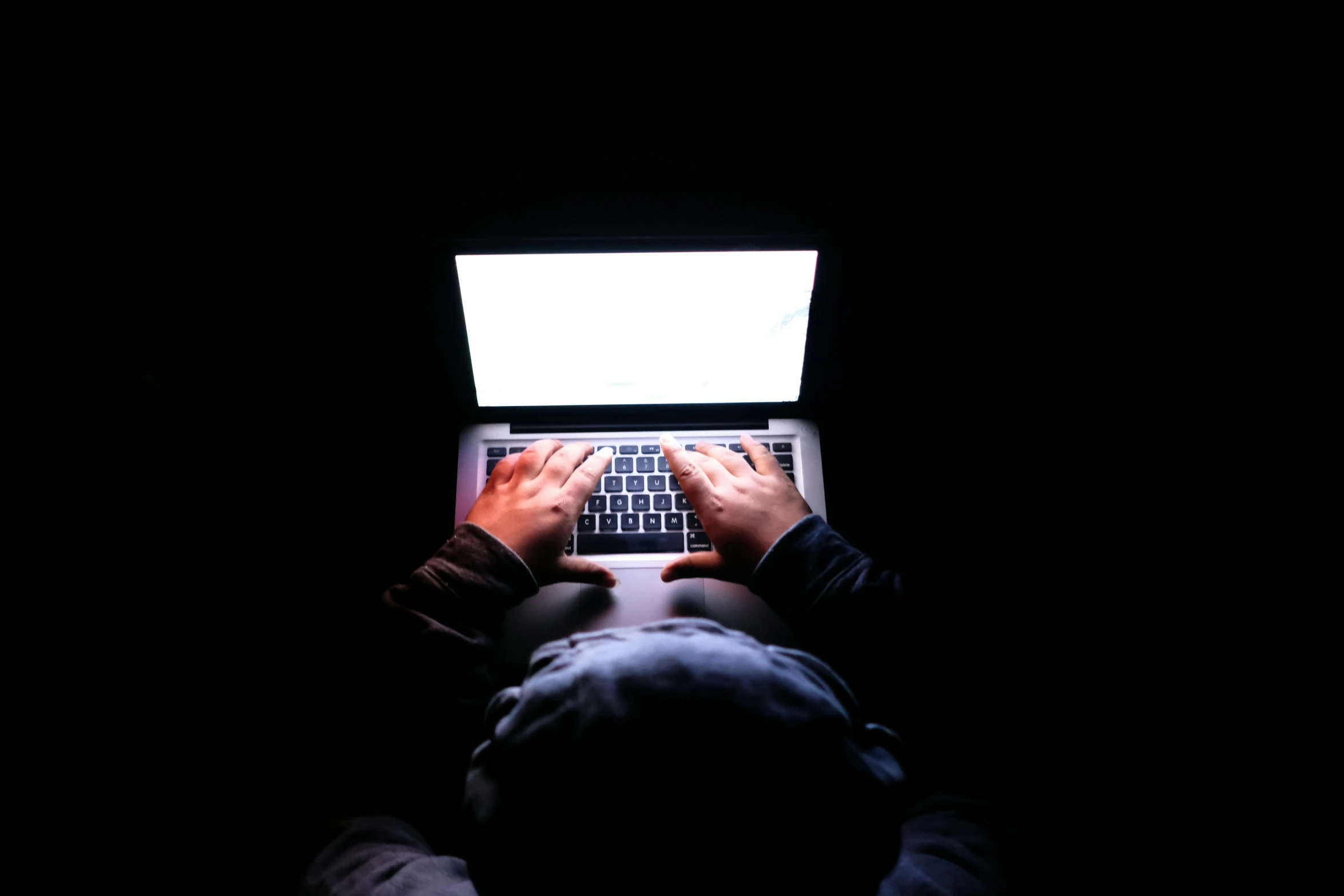 person with a laptop in the dark at night