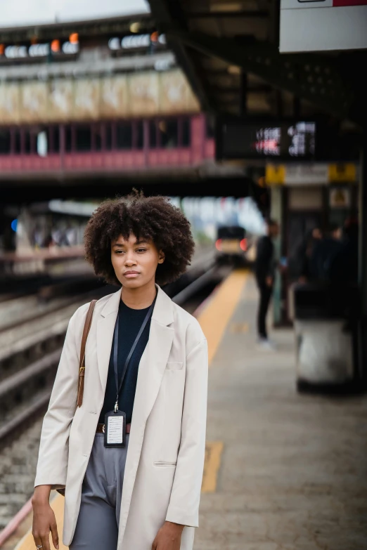 a person wearing a hat is standing on the train tracks