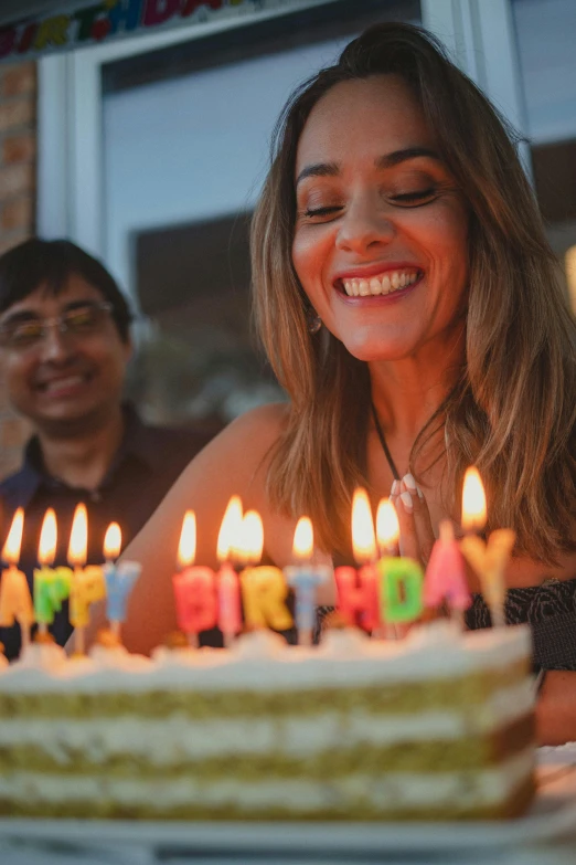 there is a woman and a man next to a cake with candles