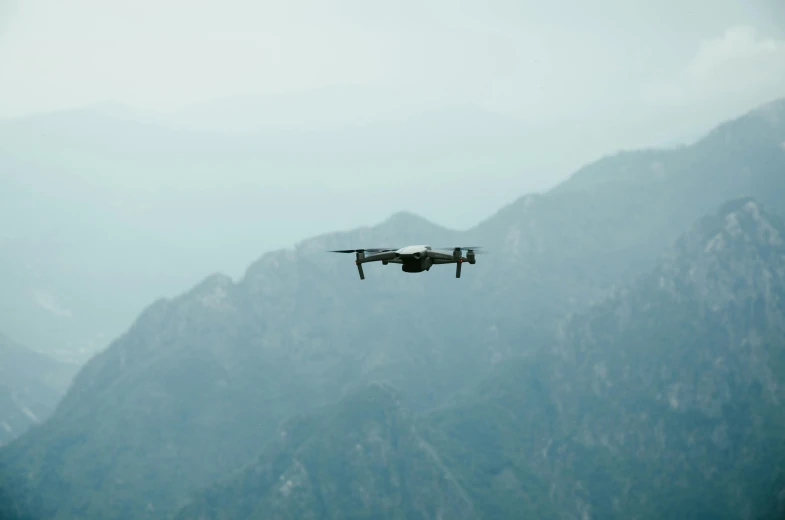 a large military plane flying over a mountain