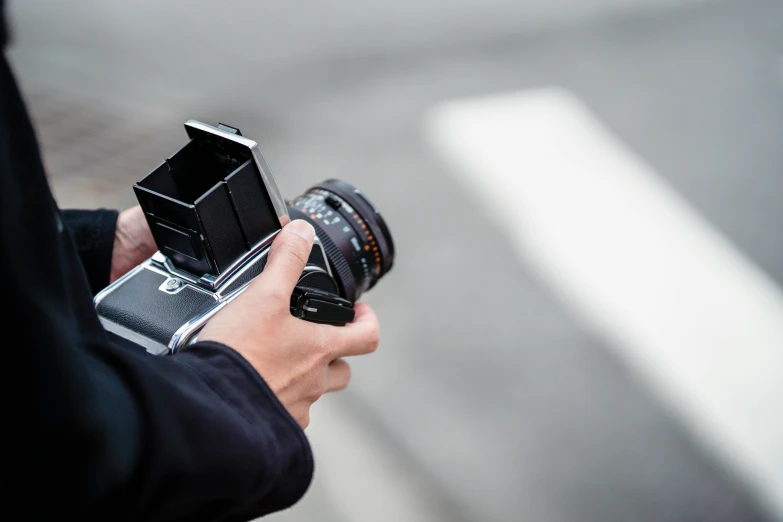 a person holding a camera, looking into the lens