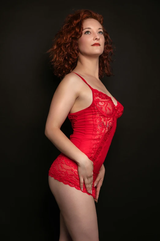 a woman in a red lingerie standing with her legs crossed