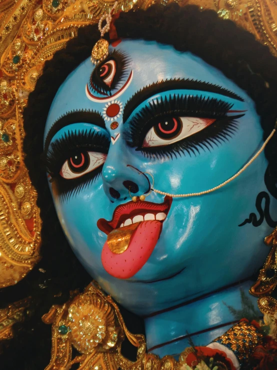 a blue face is shown with red lips and lashes