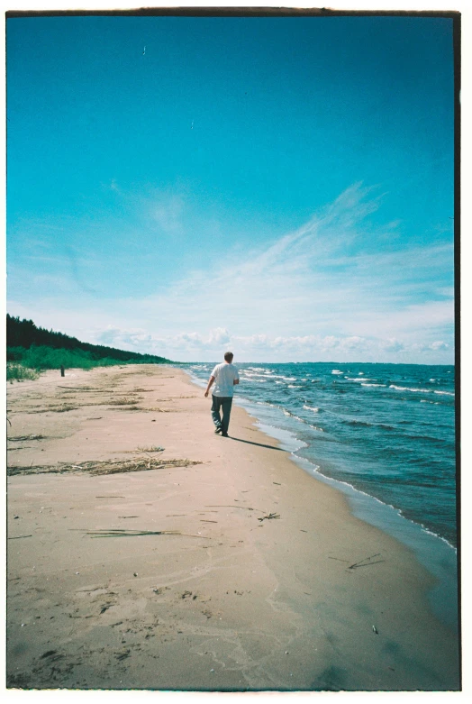 a person walking on the sand near the ocean