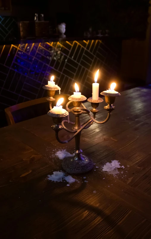 a lit candle sits on a wooden table