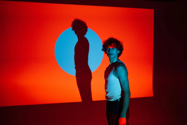 a woman in shorts posing for a po with a wall lit up behind her