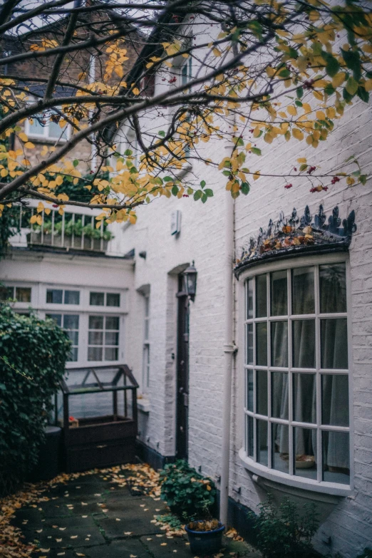 a house sitting on the side of a tree filled street