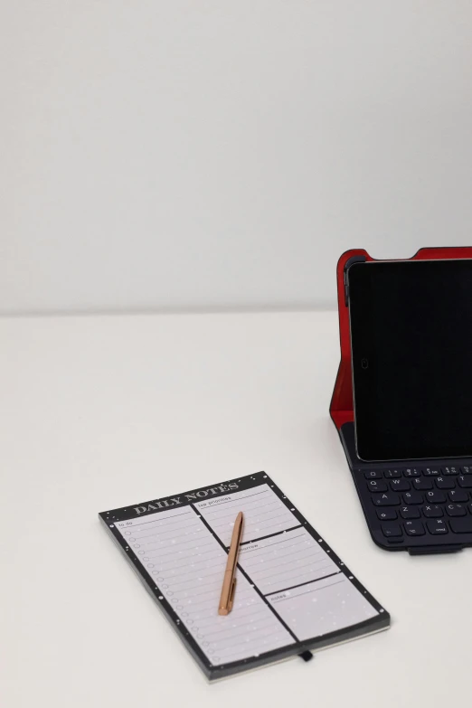 a table with a pen, calculator and notebook