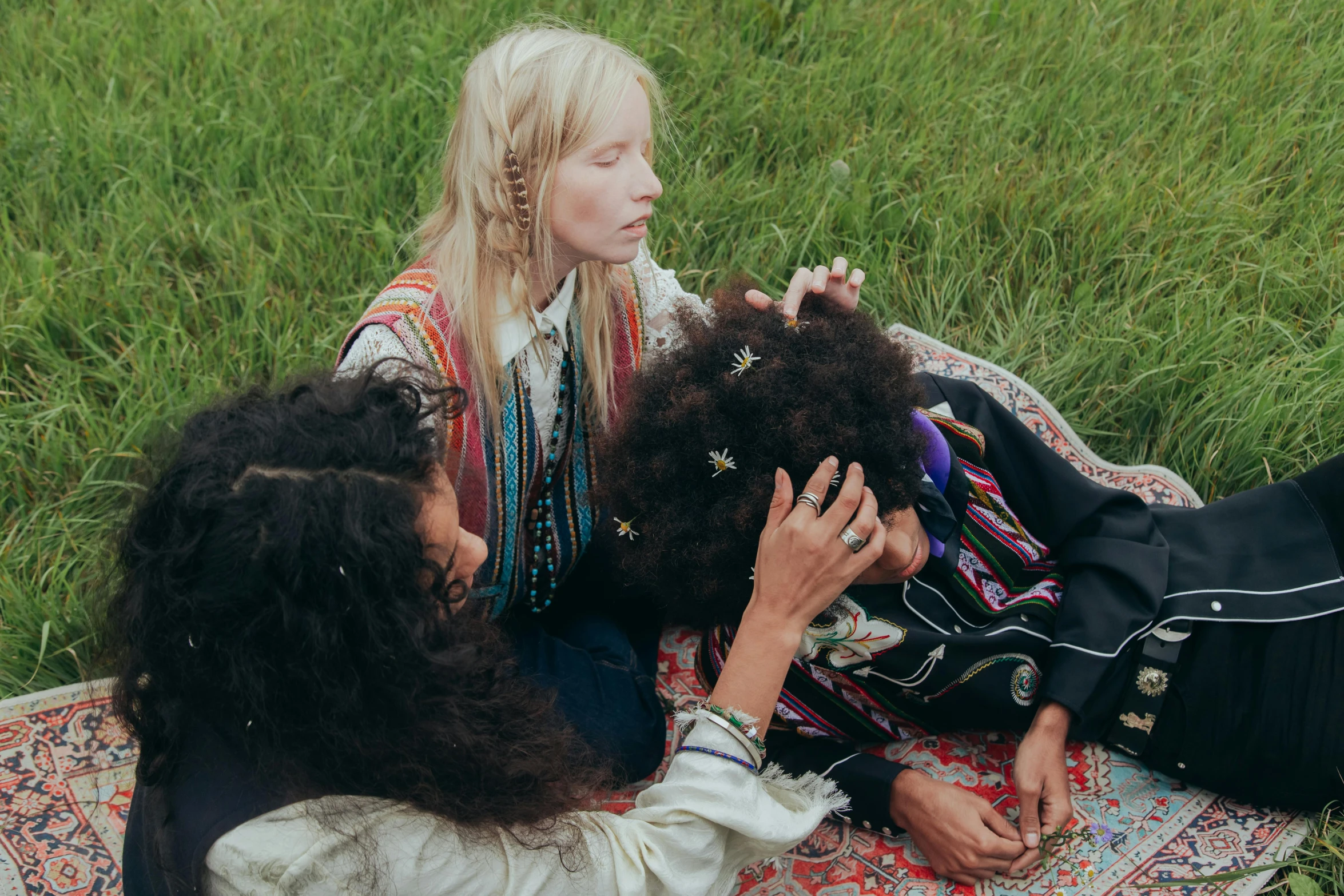 three women who are sitting on a rug talking