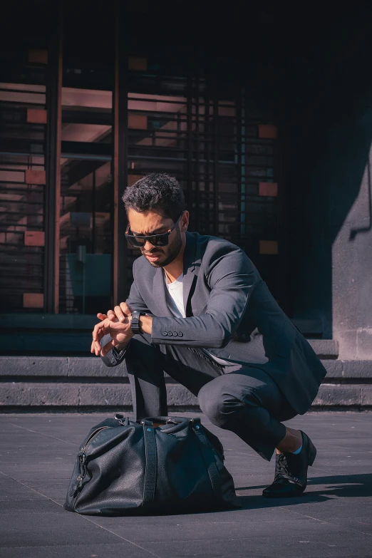 a man leaning over looking down at soing in a bag