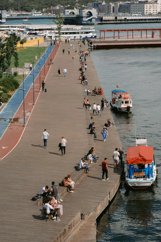 people are on the edge of a long walkway over the water