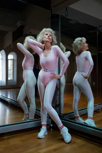 two women in full bodysuits are standing in front of a mirror