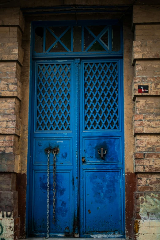 a blue and yellow door with chains hanging out of it