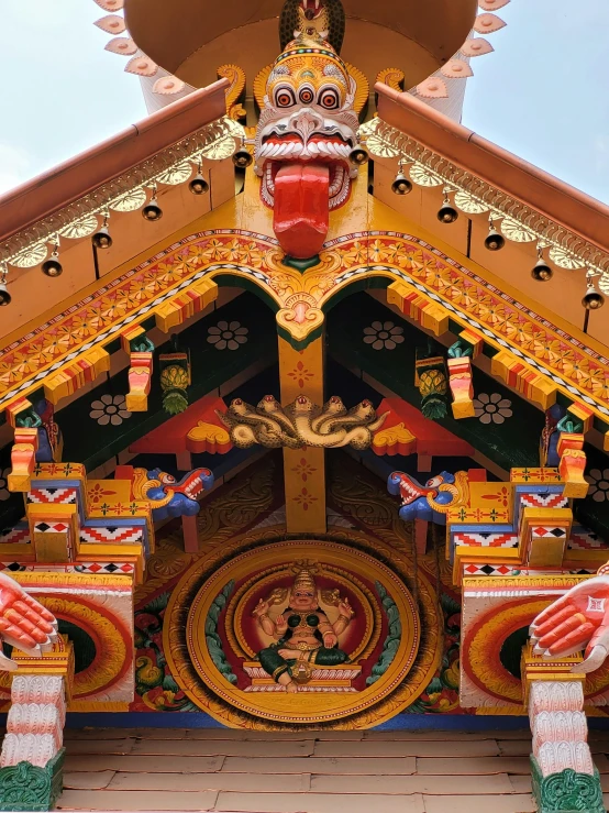an ornate asian structure with a giant painted demon on it