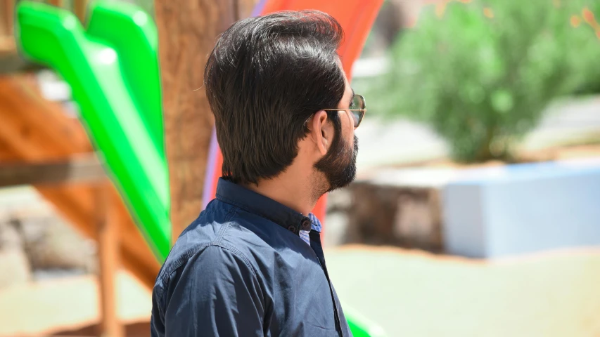 man looking off into the distance standing in front of colorful structures