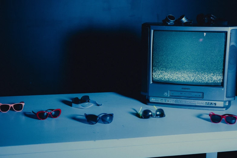 a tv and some sunglasses are on a table