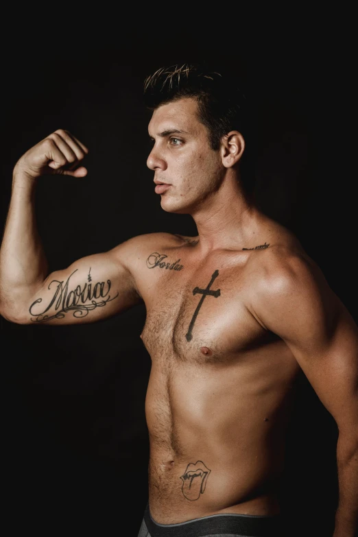 a young man is flexing his muscles with cross tattoos