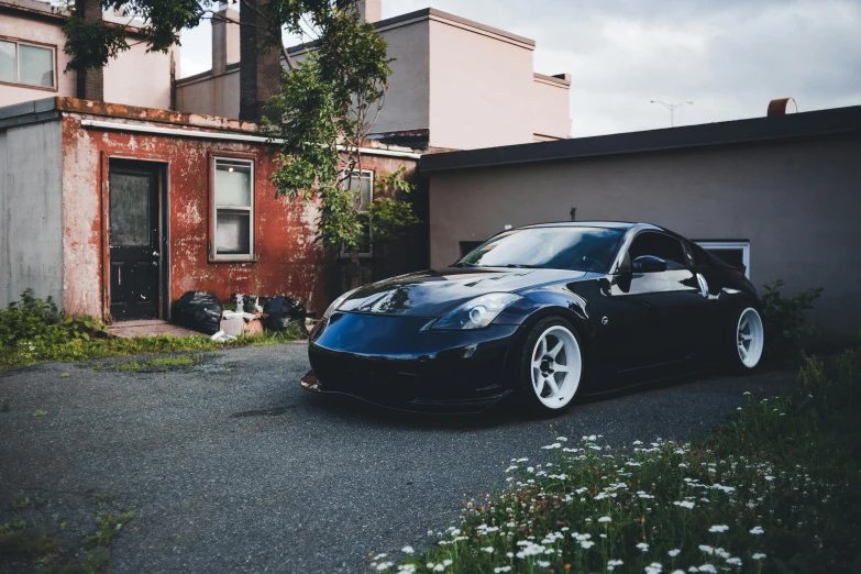 a dark colored car is parked next to an old building