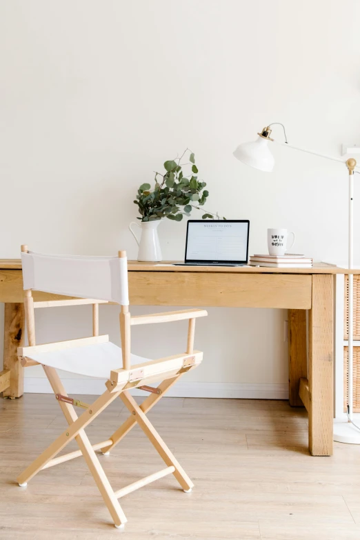 a chair sitting on top of a wooden desk next to a computer