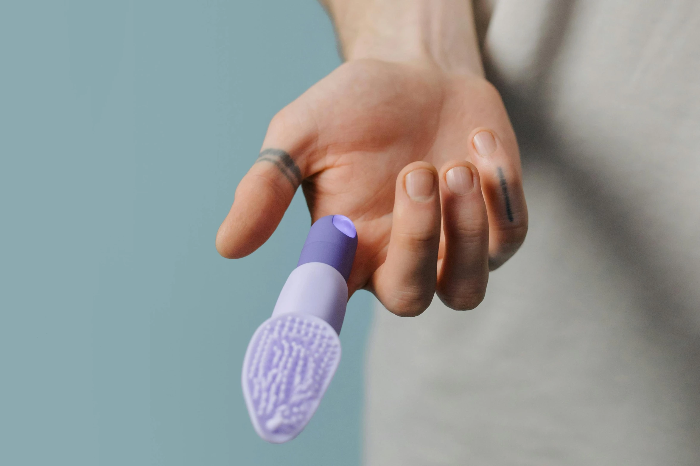 a hand holding a tooth brush next to the camera