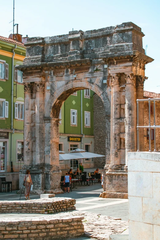 an old archway with people eating in it