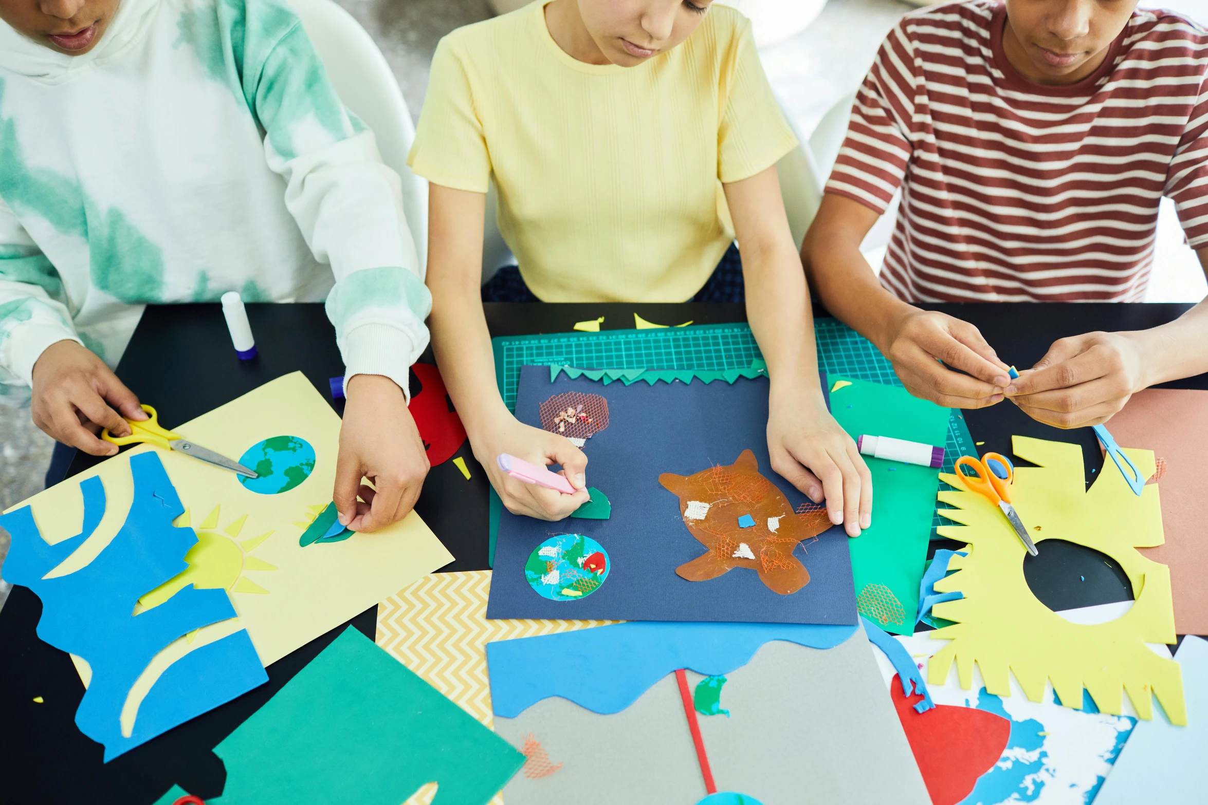 three people working on an arts and crafts project