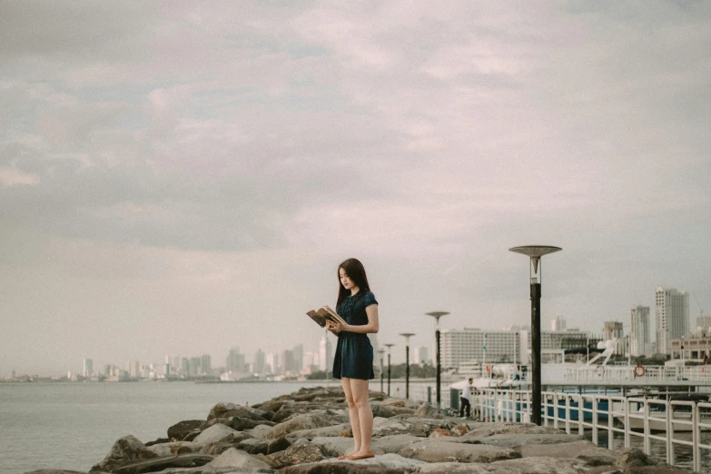 woman standing by a body of water and a pier