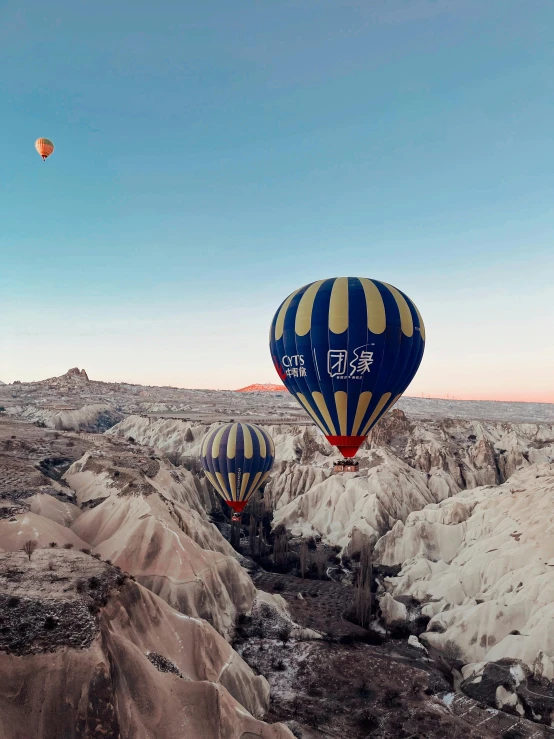  air balloons fly over a rocky valley