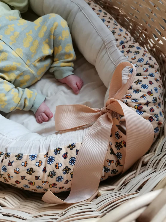 a baby sleeping inside of a wicker basket