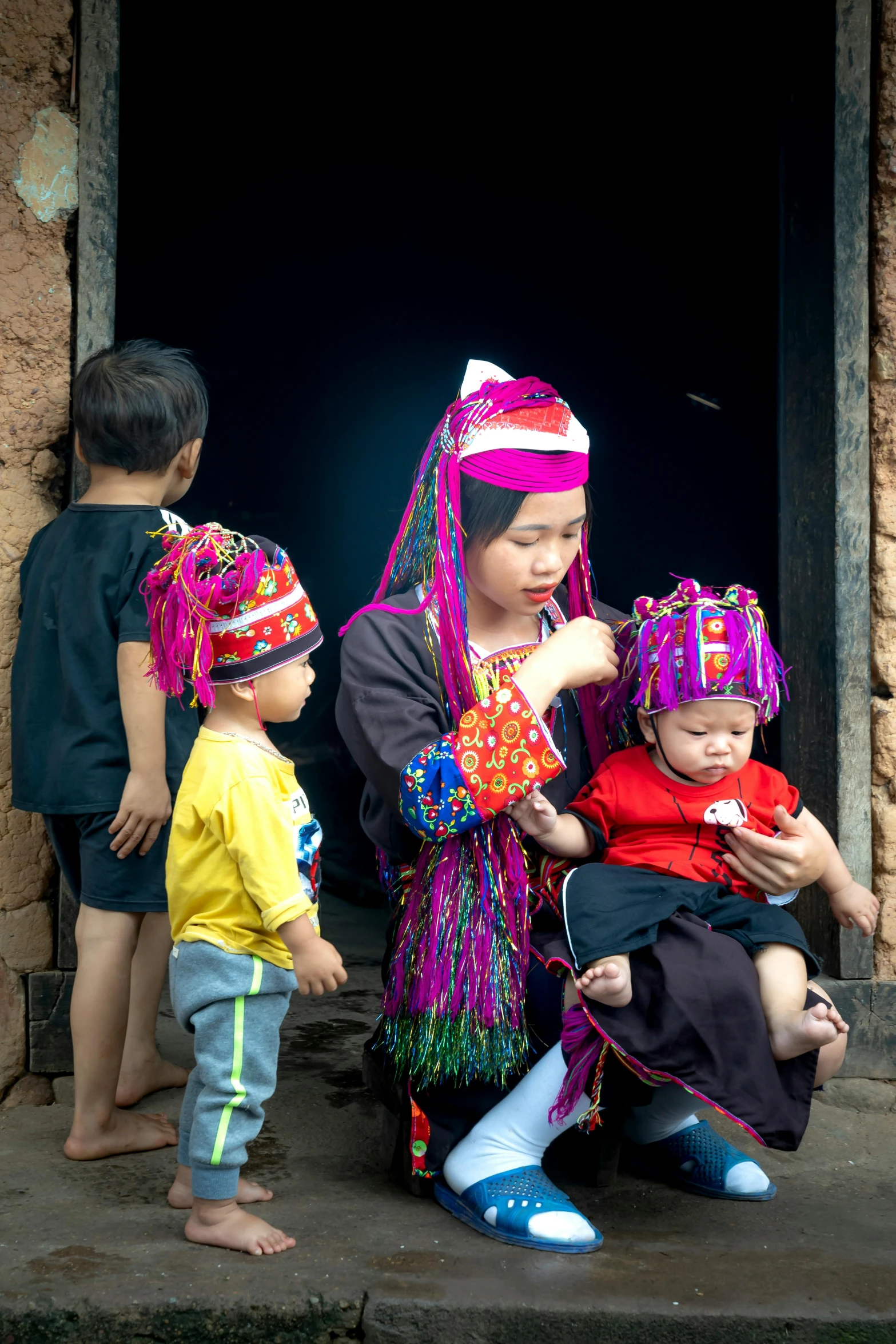 three young children sit around with their mother