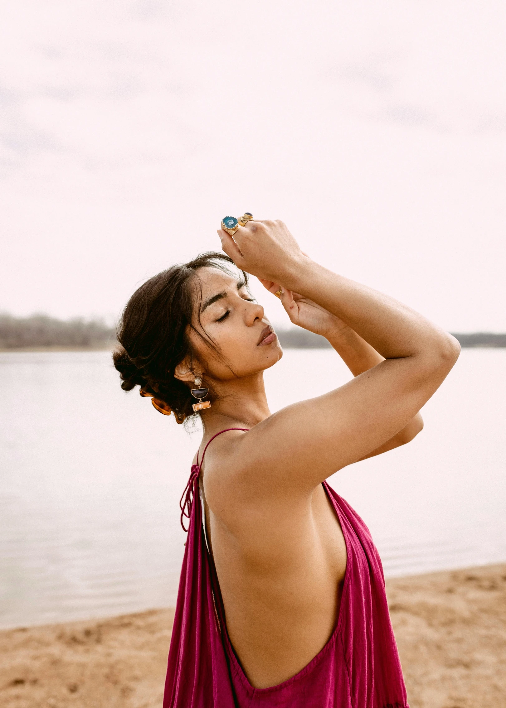 a woman with very large  standing in front of the water