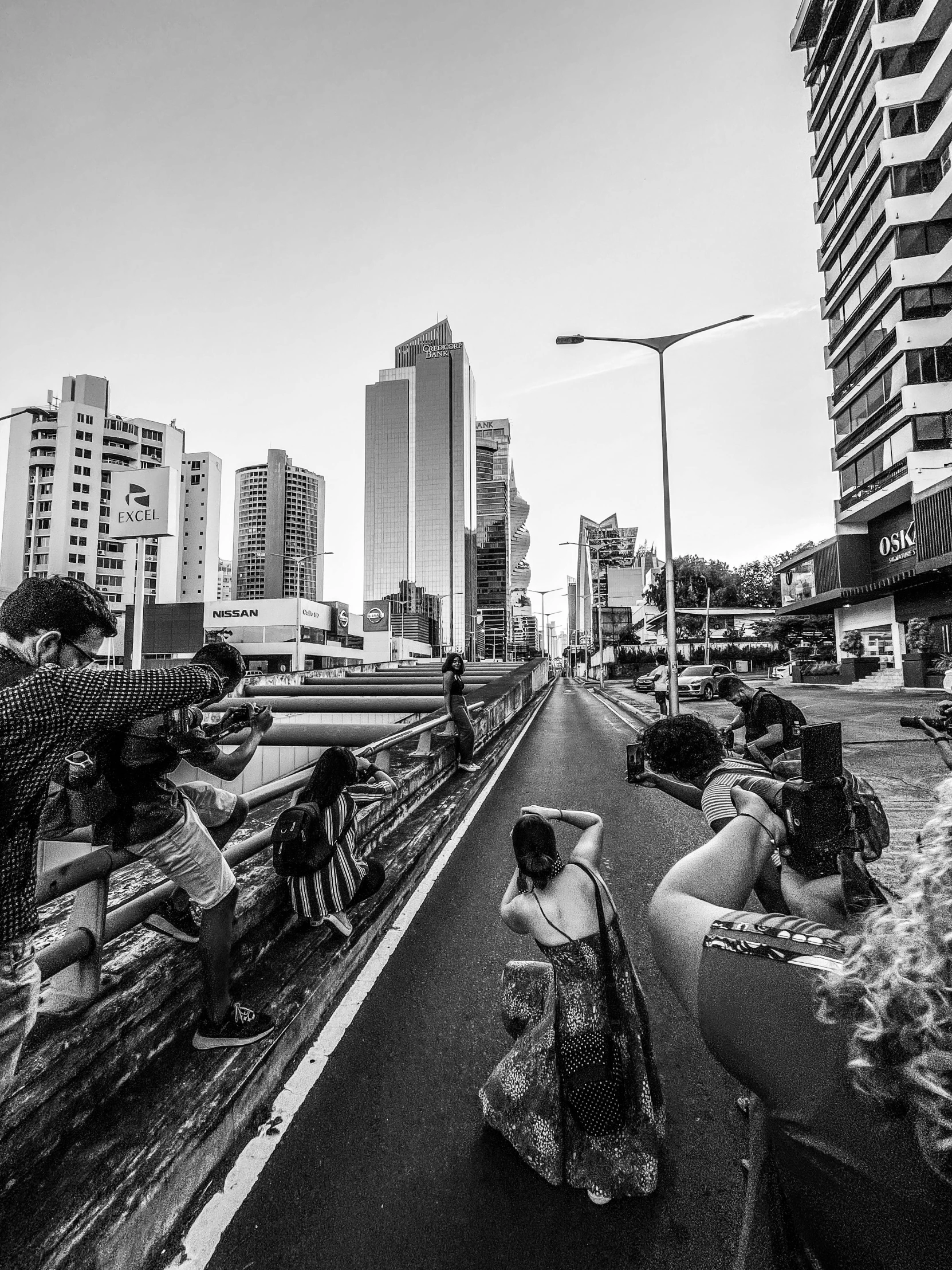 black and white image of people on scooters on a city street