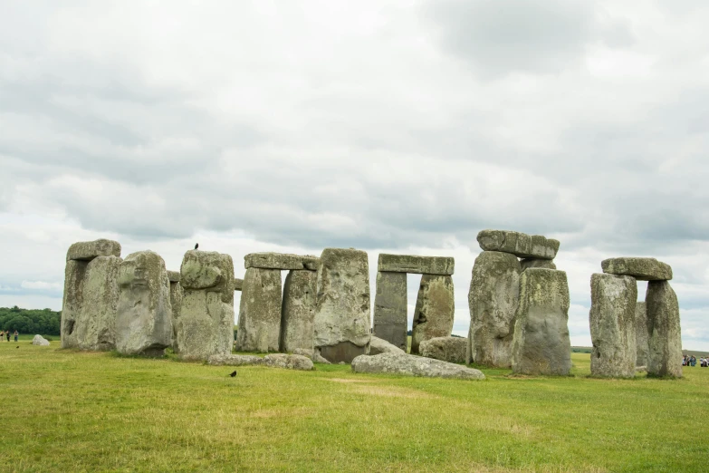 a large stone monument on grass next to a blue sky