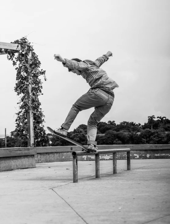 a skateboarder performing an ollie with a wooden rail near a vine