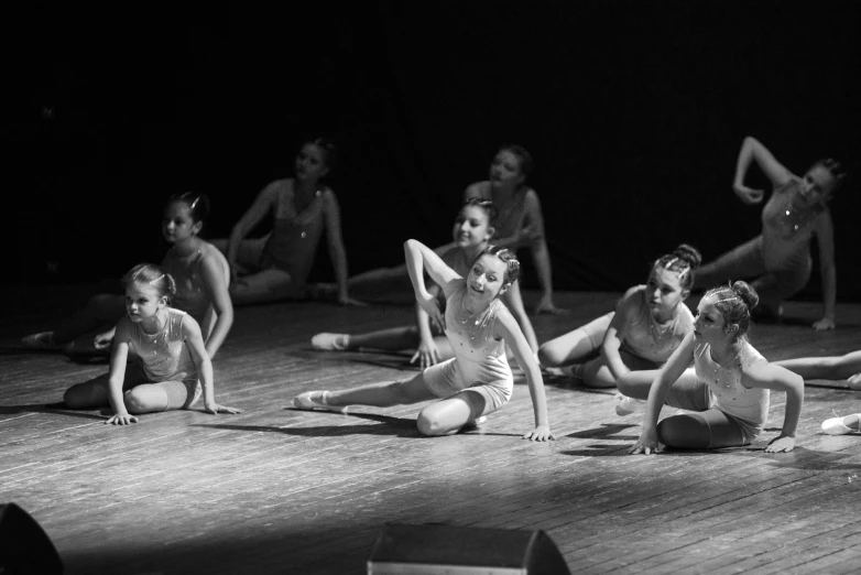 group of ballet dancers in motion on the floor