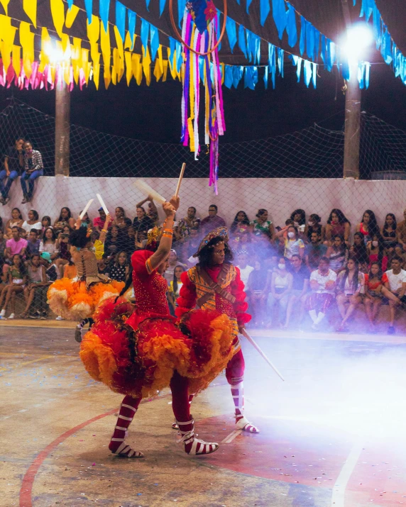 performers in colorful costumes perform a dance at an event