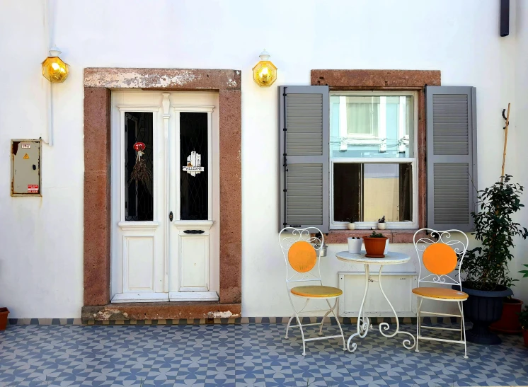 a small restaurant table with chairs next to a white door