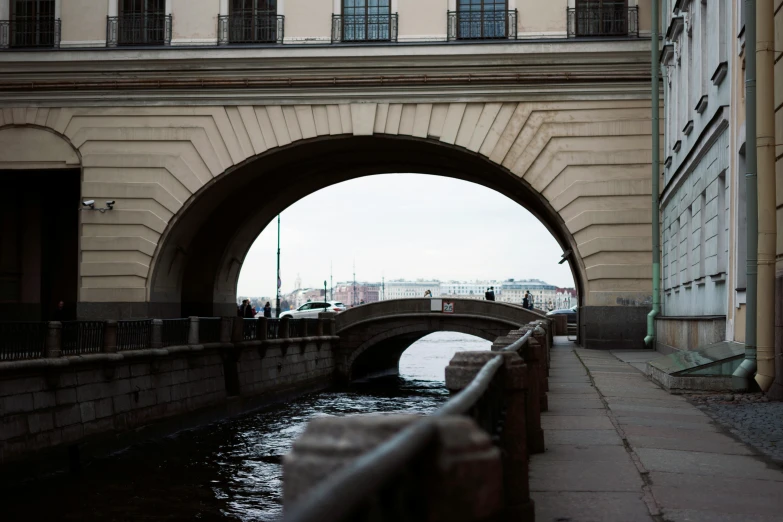 an arched street bridge over a river in the city