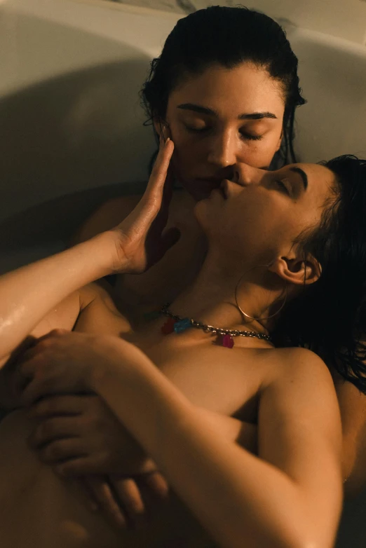 a young couple is cuddling in the bathtub