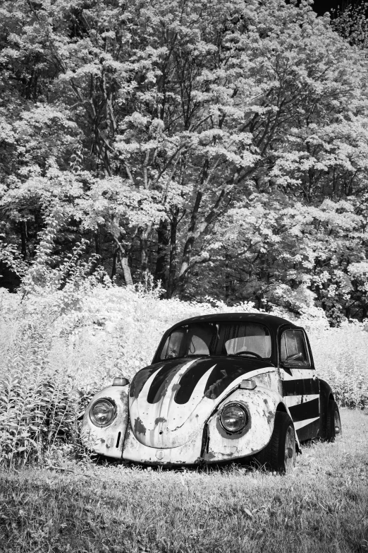 an old car sitting in a field near some trees